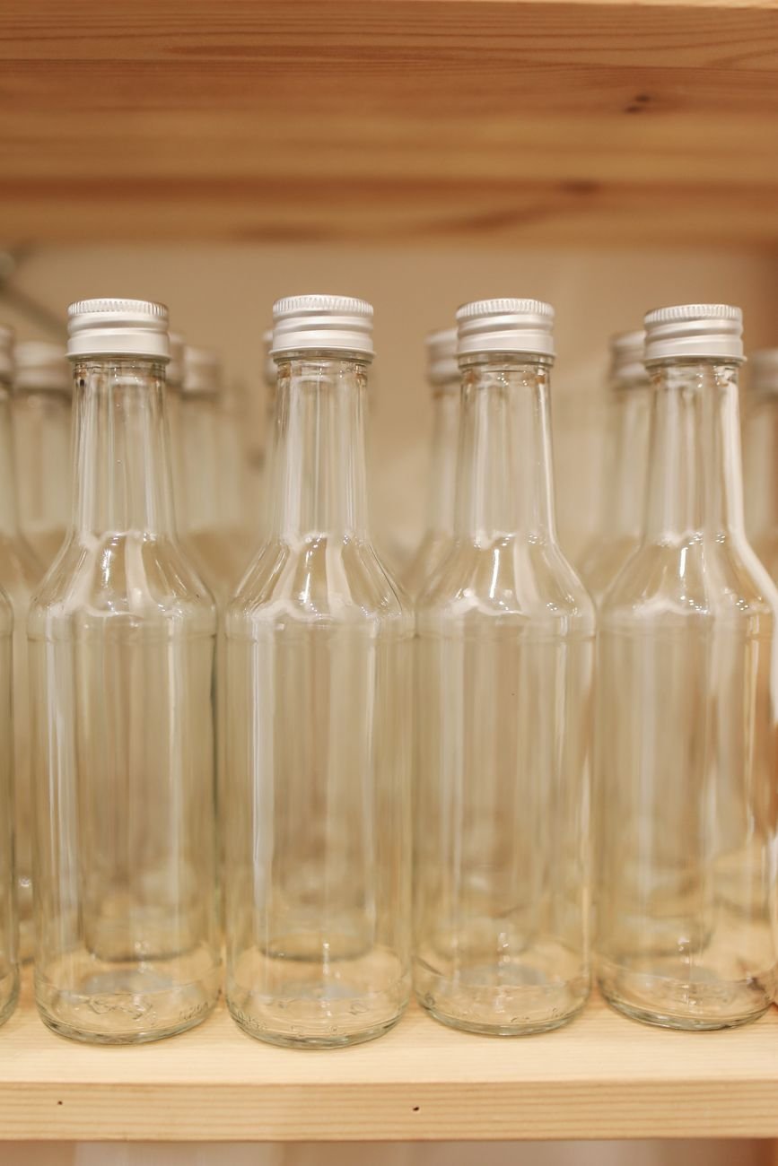 Transparent glass bottles on a wooden shelf — eco-friendly storage